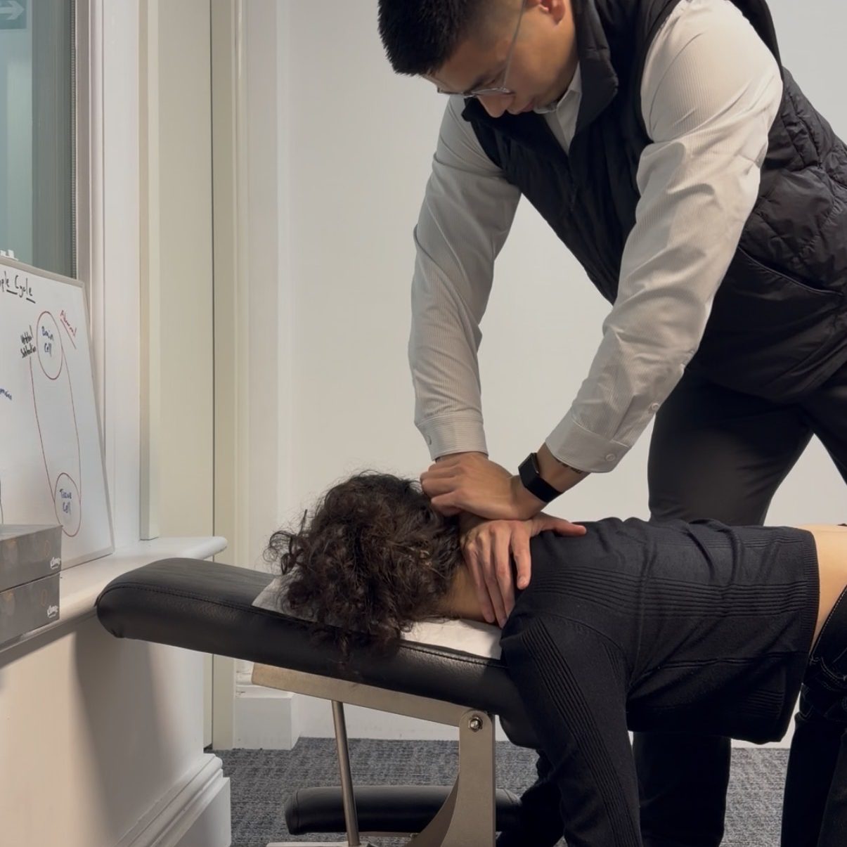 A chiropractor performing a gentle upper cervical spinal adjustment on a patient lying on a chiropractic treatment table.