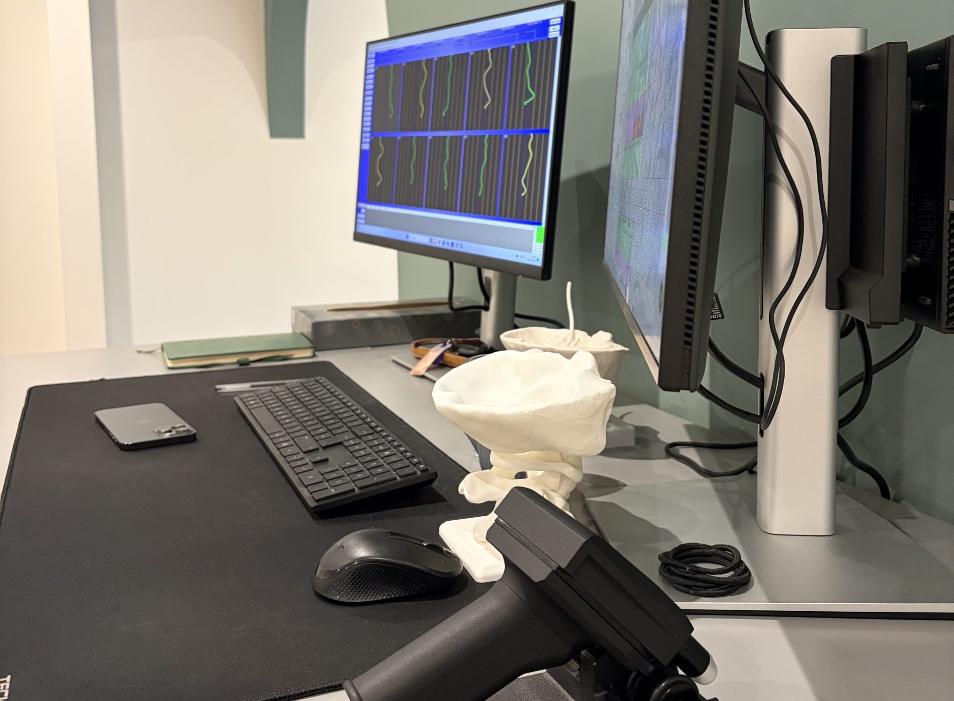 specific upper cervical chiropractic assessment desk featuring spinal analysis software, a cervical spine model, and diagnostic equipment.